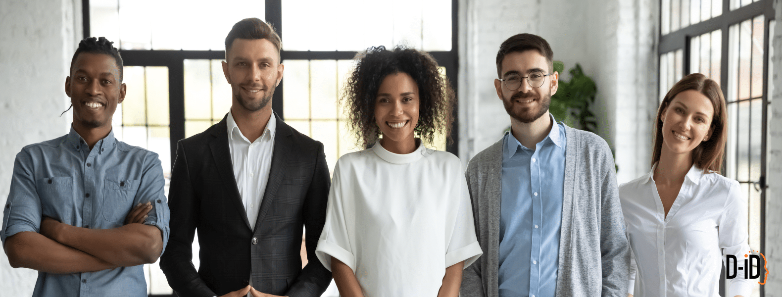 Five professionally dressed people stand side by side indoors, smiling at the camera in a well-lit office space, embodying teamwork enhanced by AI companion technology.